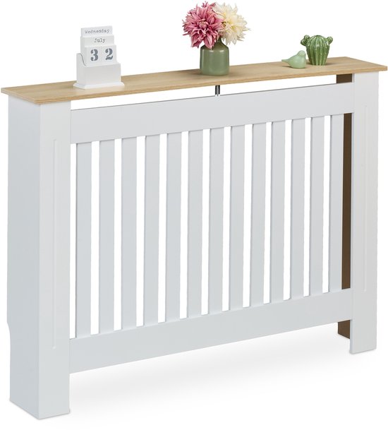 Witte radiatorombouw met een houten blad, verticale spijlen en decoraties.