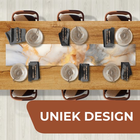 Table dressée avec six assiettes et couverts, avec un chemin de table central en vinyle à imprimé marbre gris, blanc et doré.