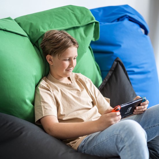 Jongen zit op een zwarte zitzak en speelt op Nintendo Switch, omringd door andere zitzakken.
