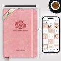 Roze A5 budget planner met elastiek, met geld-icoon en 'Budget Planner' opdruk. Naast een smartphone.
