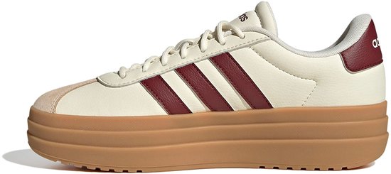 Crème lage sneaker met dikke bruine zool en bordeauxrode strepen en hielpand met Adidas logo.