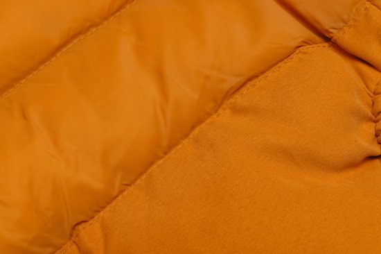 Detail van een oranje hondenjas met doorgestikte naden.