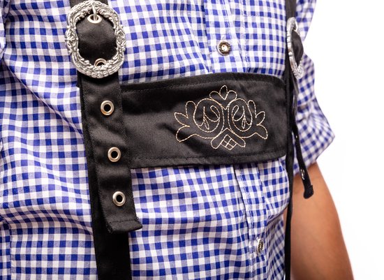 Blauw geruite blouse met zwart lederhosen met geborduurde details en zilveren gespen.