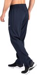 Man in donkerblauwe sportbroek met ritsen aan de zijkant en witte sneakers.