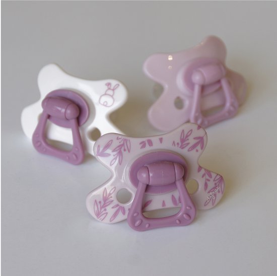 Drie roze en witte Difrax fopspenen met blaadjesprint en paarse ring.