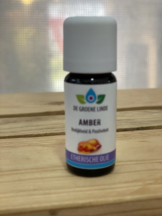 Flesje amber etherische olie van De Groene Linde, met etiket met 'Amber Vrolijkheid & Positiviteit'.