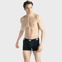 Man met zwarte boxershorts met witte Adidas-band.