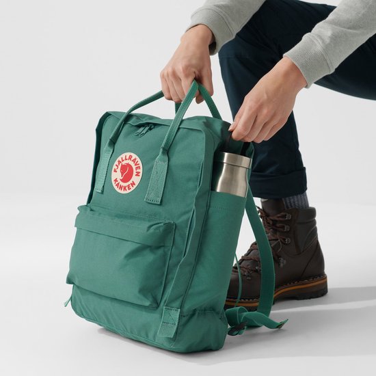 Groene Fjällräven Kånken rugzak met een waterfles in het zijvak.