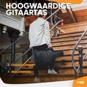 Man draagt een zwarte, hoogwaardige gitaartas op een houten trap. Tekst: 'HOOGWAARDIGE GITAARTAS', 'DRAAGCOMFORT', 'BESCHERMING'.
