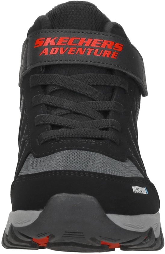 Voorkant van een zwarte wandelschoen met veters, klittenband en 'WATERPROOF' logo.
