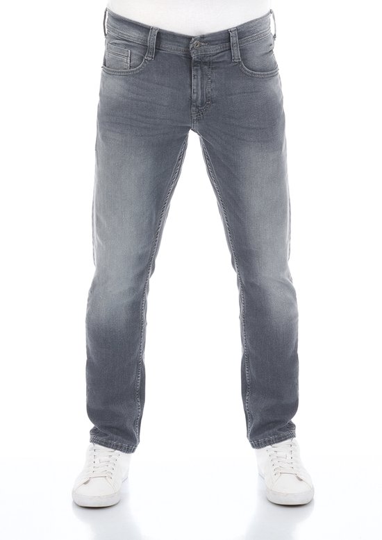 Man in grijze tapered fit jeans en witte sneakers, van voren gezien.