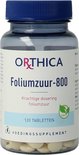 Doorzichtige pot Orthica Foliumzuur-800 met blauwe dop en witte tabletten. De tekst op het etiket is in het Nederlands en bevat een groen vegan logo.