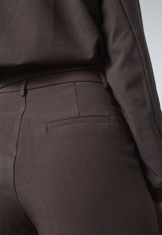 Bruine broek met een opgestikte achterzak en gespleten tailleband.