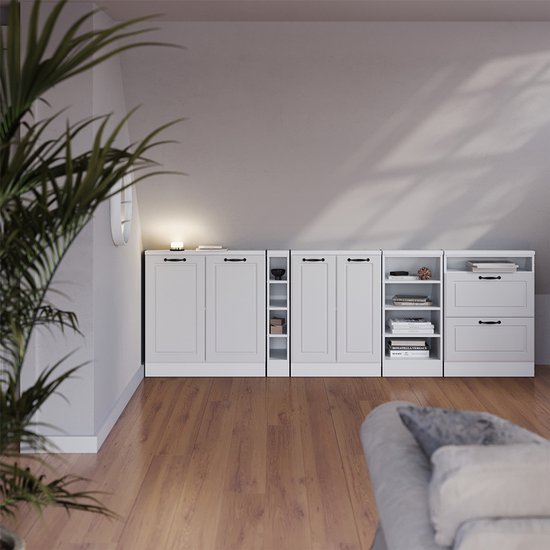 Stel witte kasten, waaronder een kast met twee deuren, een smalle kast met open vakken, een kast met twee deuren en een kast met lades, in een woonkamer.