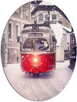 Dibond Ovaal - Rood met Wit Gekleurde Tram Rijdend door Besneeuwde Stad - 81x108 cm Foto op Ovaal (Met Ophangsysteem)