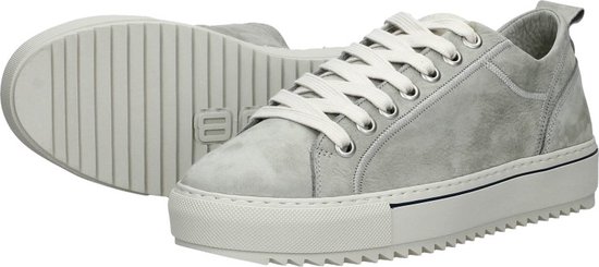 Paar lichtgrijze lage veterschoenen, één op de zijkant, de ander op de zool, met crèmekleurige veters.
