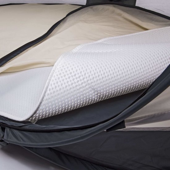 Het geperforeerde, witte matraskussen wordt uitgevouwen op het off-white babymatras in de donkergrijze hoes.