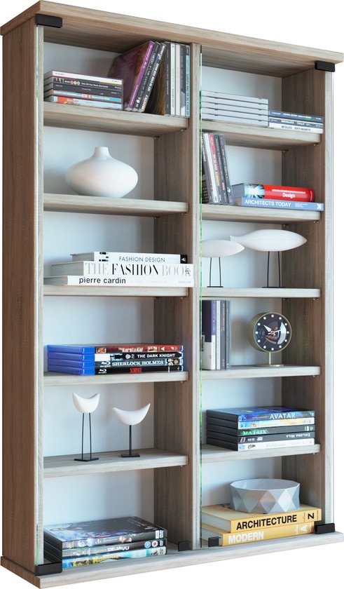 Une haute et étroite bibliothèque en bois clair, six étagères avec divers livres, CD et objets décoratifs. L'armoire a des portes vitrées.