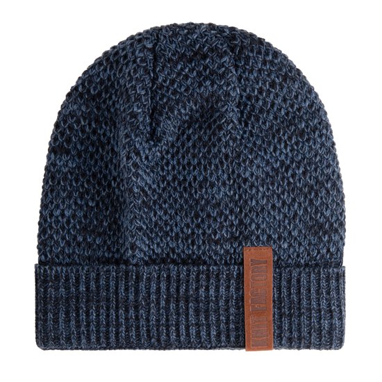 Een blauw gemêleerde gebreide muts met ribbelboord en een bruin leren label van Knit Factory.