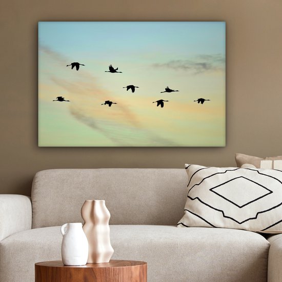 Tableau sur toile Un ciel bleu-jaune avec huit grues - 90x60 cm - Décoration murale
