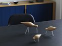 Drie houten vogeldecoraties met witte, metalen pootjes op een zwarte tafel.