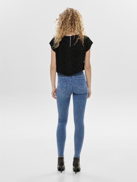 Model van achteren in blauwe skinny jeans met middelhoge taille en zwarte top.