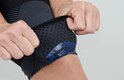 Een close-up van de binnenkant van een zwarte compressie kniebrace met blauwe gelstabilisatoren.