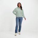 Model draagt een mintgroene NOMAD hoodie met klein geel logo en jeans.