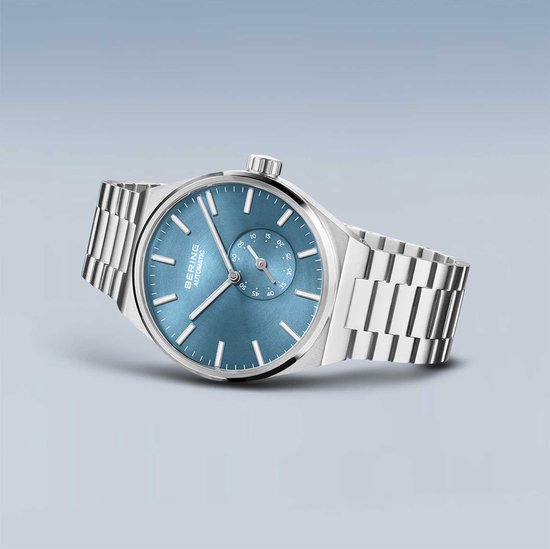 Zilverkleurig horloge met blauwe wijzerplaat en zilverkleurige band. BERING AUTOMATIC.