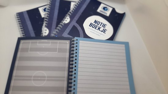 Een geopend notitieboek met een voetbalveld op de linkerpagina en lijntjes op de rechterpagina.