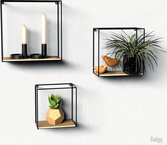 Drie vierkante wandrekken met houten plankjes, versierd met kaarsen, plantjes en decoratieve vogels.