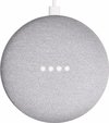 Grijze Google Nest Mini met witte kabel, gezien vanaf de bovenkant, met vier witte led-lampjes.