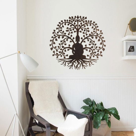 Zwarte Boeddha in levensboom metaal kunstwerk aan een witte muur bij een fauteuil en plant.