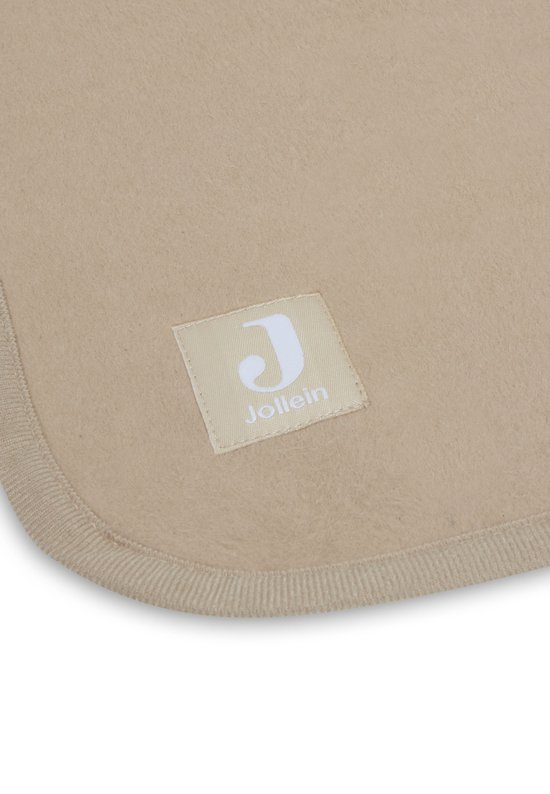 Detail van de hoek van een biscuitkleurige babydeken met een Jollein logo label en gebreide rand.