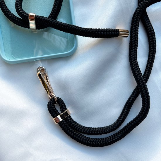 Zwart telefoonkoord met gouden ringen en een gouden karabijnhaak die aan een telefoonhoesje is bevestigd.