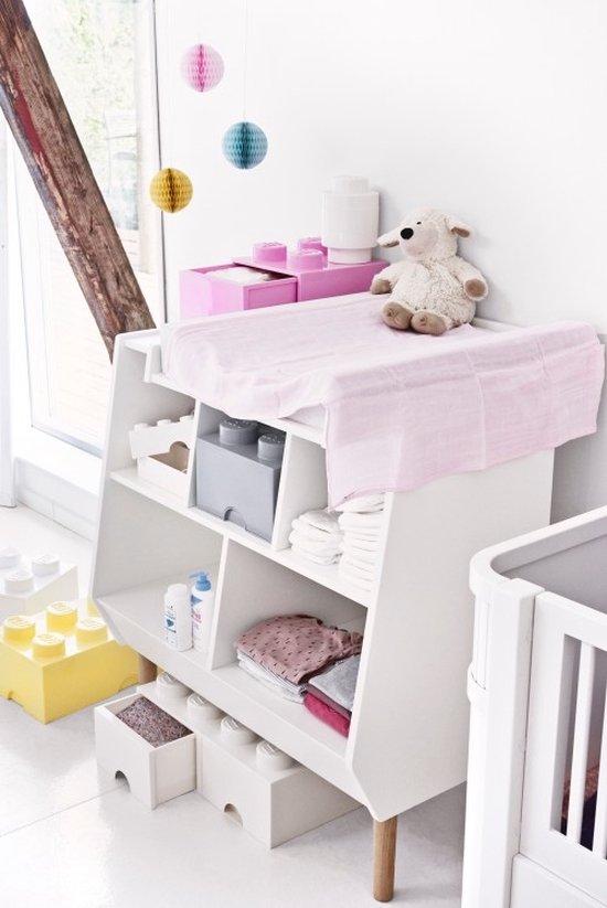 Babykamer met commode, speelgoed en decoratie, met gele en witte LEGO opbergboxen.