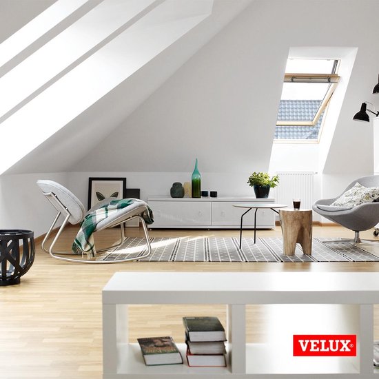 Salon avec fenêtre de toit VELUX. Deux fauteuils et une table basse. Logo VELUX.