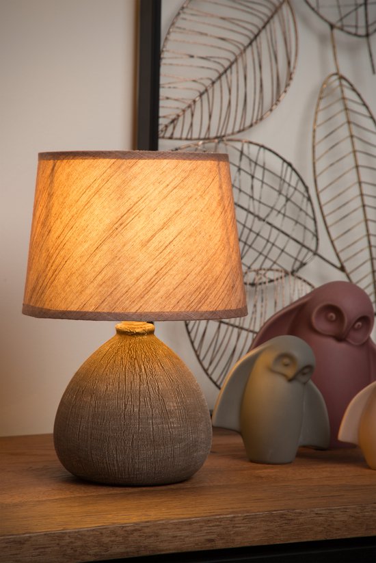 Lampe de table marron texturée avec abat-jour conique. Trois hiboux décoratifs à l'arrière.