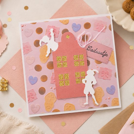 Kaart met roze huis, engel, pieten en speculaas figuren. Tekst 'Badeautje'.