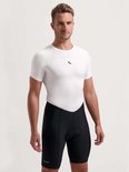 Man in wit fietsshirt met korte mouwen, zwart Rogelli fietsbroek met brede, zwarte elastieken banden aan de pijpen. Zwarte opdruk op shirt.
