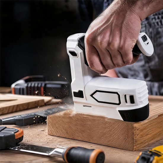 Hand gebruikt een wit-zwart elektrisch nietpistool op een houten balk, omringd door gereedschap.