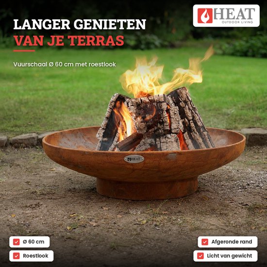Lichtgewicht HEAT vuurschaal van 60 cm met roestlook in een tuin, brandend met houtblokken, voorzien van afgeronde rand.