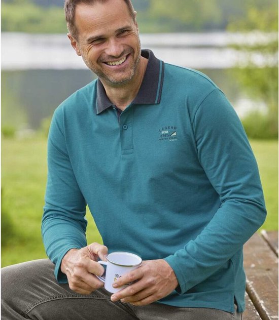 Glimlachende man in een blauwgroene poloshirt met lange mouwen en opdruk 'LEGEND WINTER STATE', buiten zittend.