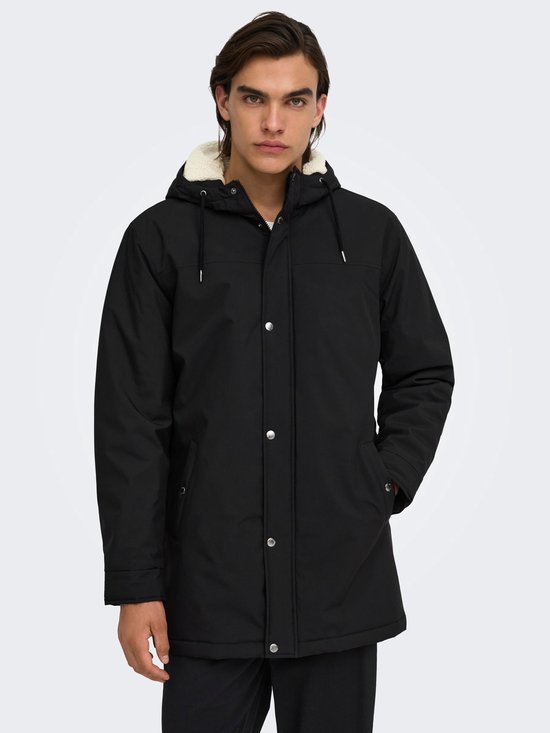 Zwarte parka met capuchon, crèmekleurige voering en zichtbare drukknoopsluiting.