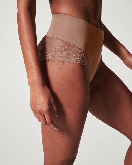 Close-up van een beige Spanx Hi-Hipster onderbroek met kanten inzetstukken op de heupen.