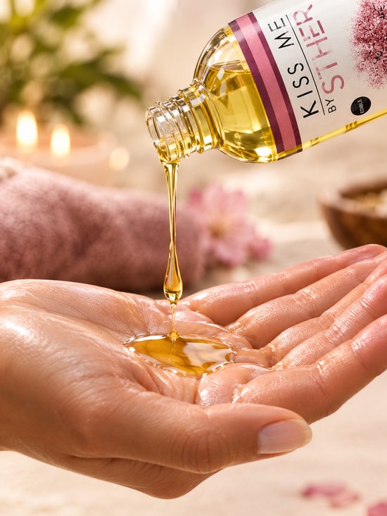 Hand met massageolie die uit een fles 'Oriental' van Sther wordt gegoten. Geur met bloeiende kersenboomillustratie.