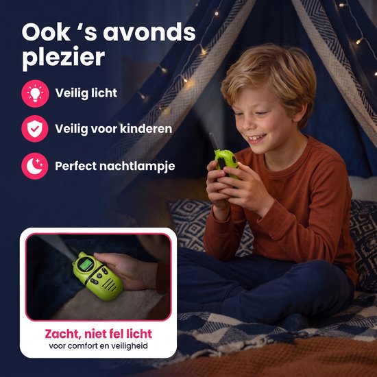 Jongen met een groene walkietalkie in een tent, die dient als nachtlampje. De walkietalkie straalt zacht licht uit.