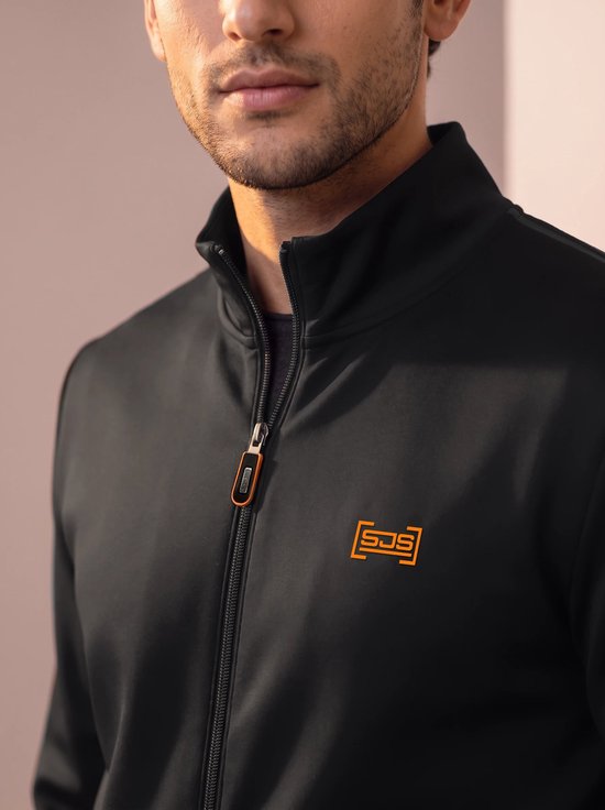 Close-up van zwart sportvest met oranje ritsdetail en oranje logo.