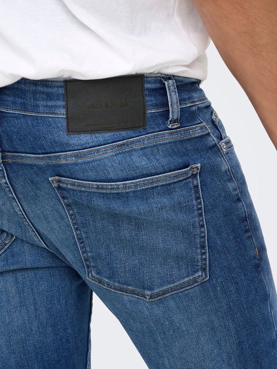 Blauwe skinny jeans met achterzak en zwart leren 'ONLY & SONS' label aan de taille.