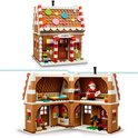 Een LEGO peperkoekhuis met witte en bruine strepen en veelkleurige ronde decoraties op het dak. Het huis opent om een gedetailleerd interieur te onthullen.